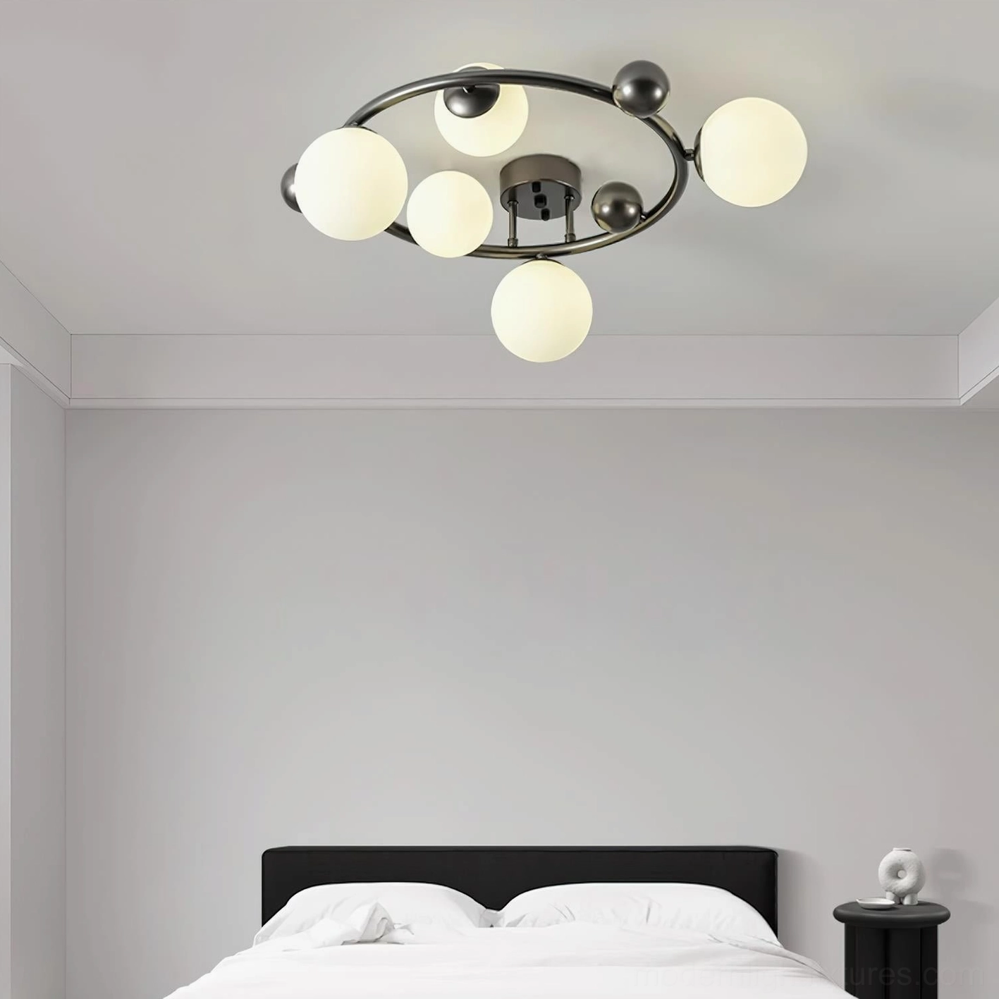 Black circular multi-globe ceiling lamp with frosted glass spheres - overhead product shot in modern bedroom