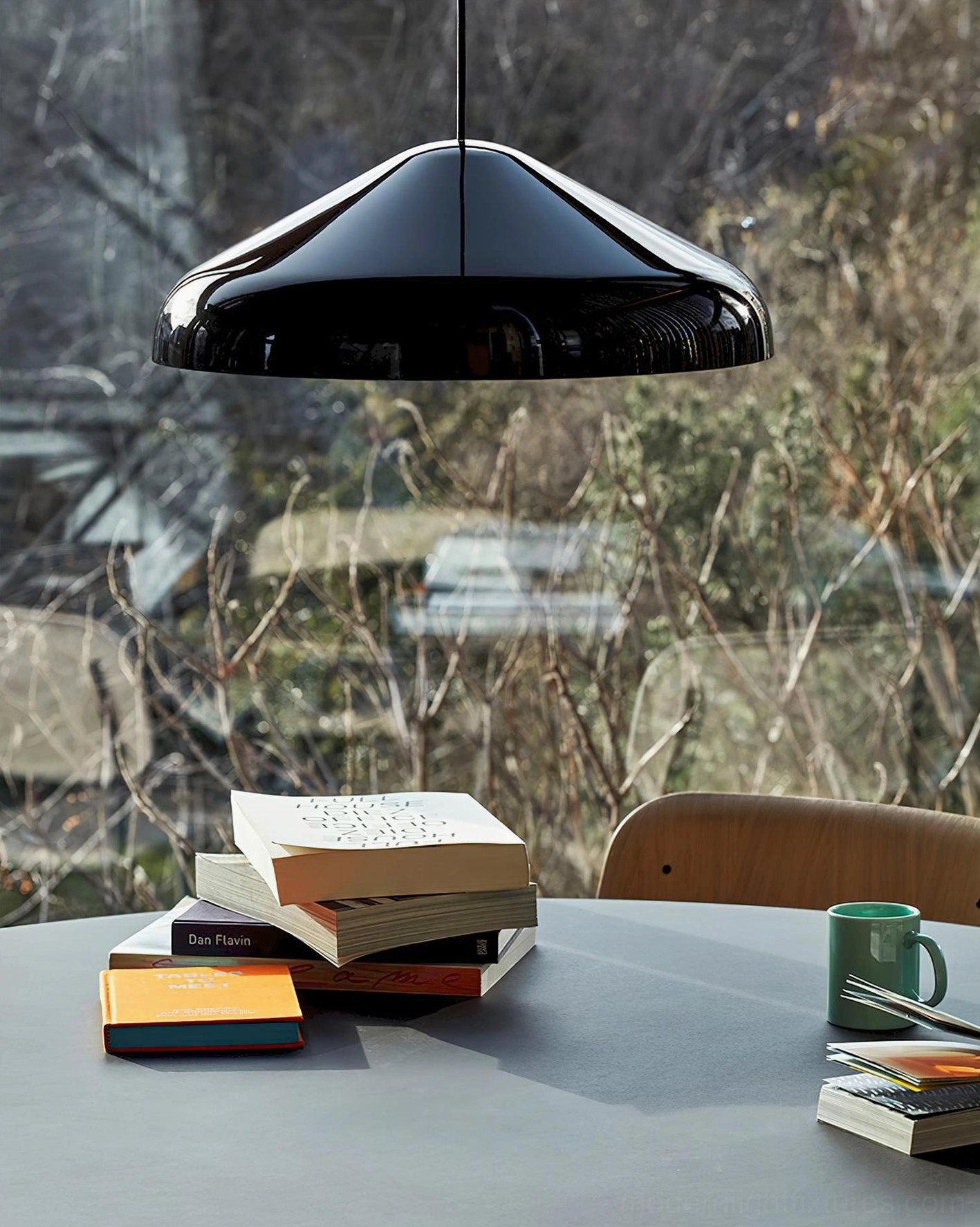 Black dome pendant light positioned above dining table setting