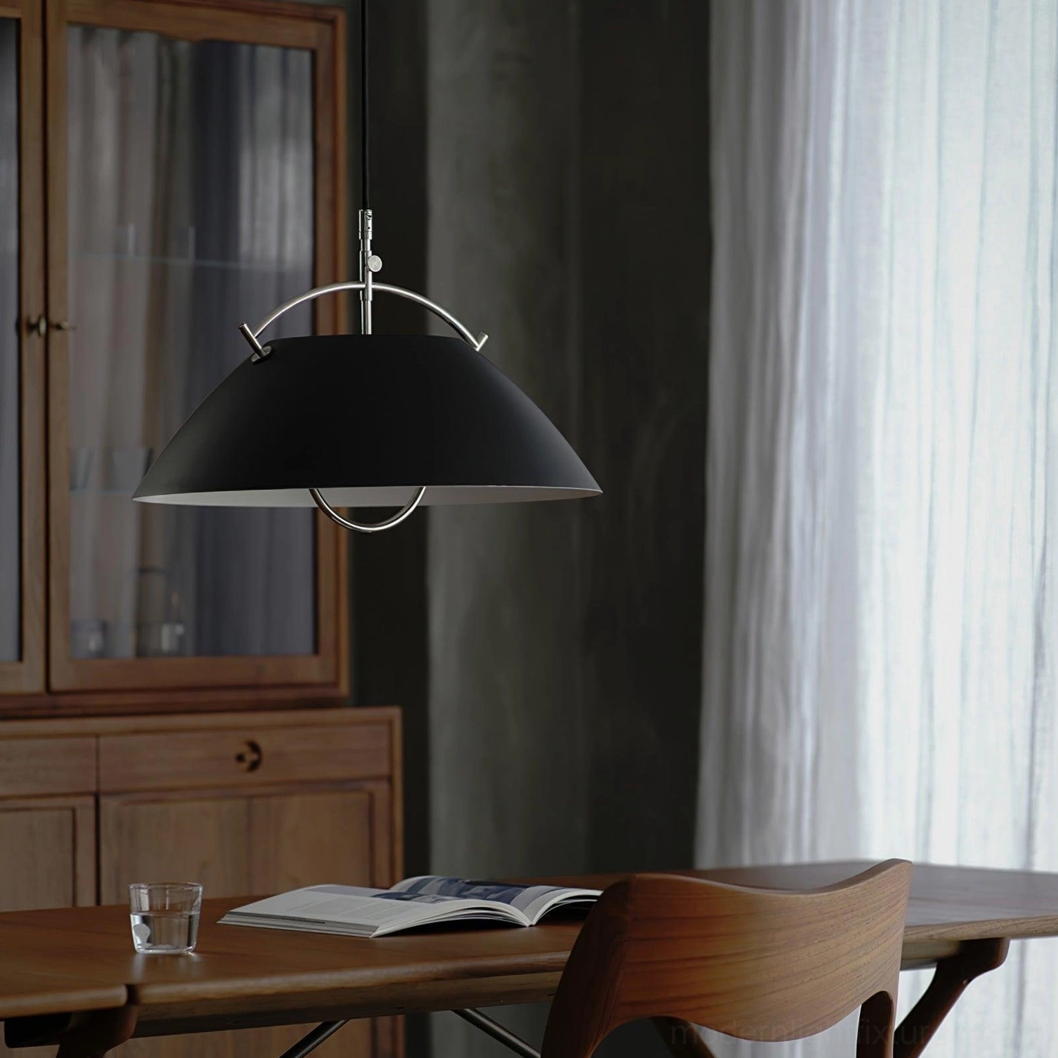 Contemporary black pendant light with silver hardware in modern dining room setting