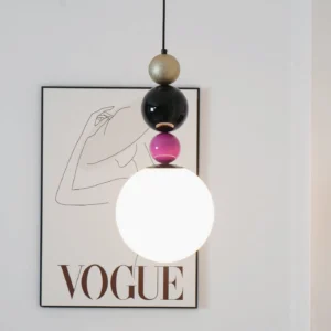 Contemporary glass sphere pendant lamp styled in minimalist modern interior with Vogue art print wall decor