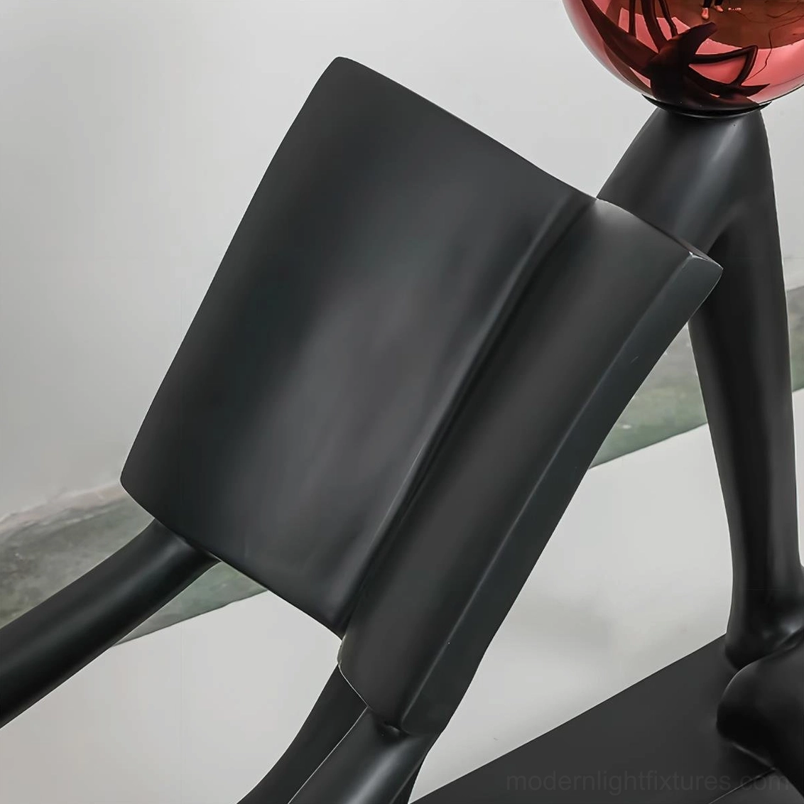 Black reader sculpture floor lamp with red accent, premium resin and glass construction, contemporary art lighting
