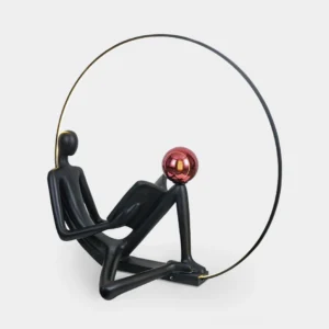 Black reading statue floor lamp with red accent globe, front studio view on white background, modern art lighting sculpture