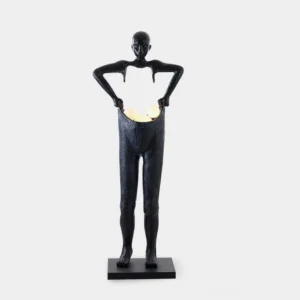 Black resin sculptural man carrying pants floor lamp with warm LED light illumination on studio background