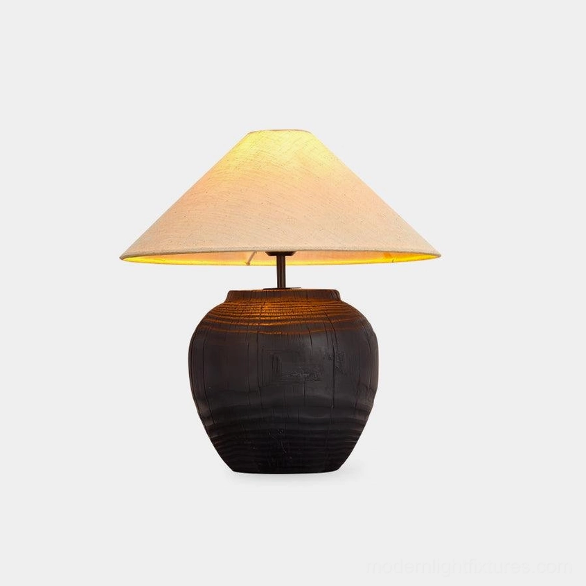 Black textured resin table lamp with fabric shade on white studio background