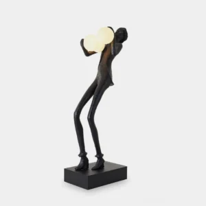 Contemporary humanoid sculptural floor lamp with frosted glass orbs, matte black resin textured body, and square black base, front left view studio shot