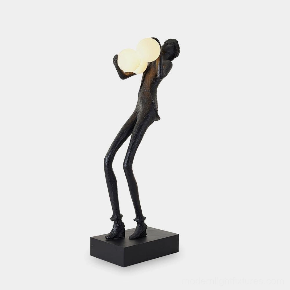 Contemporary humanoid sculptural floor lamp with frosted glass orbs, matte black resin textured body, and square black base, front left view studio shot
