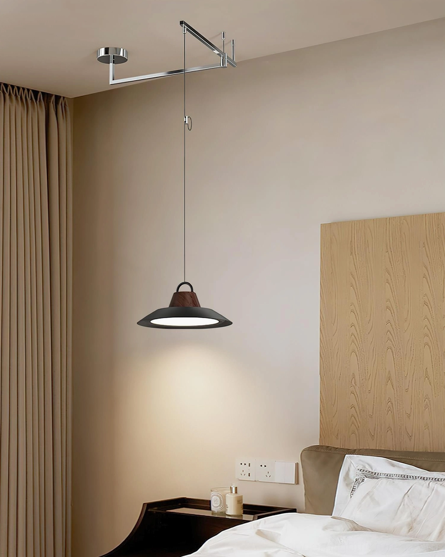 Black modern swing arm pendant light creating warm ambient lighting in contemporary bedroom space