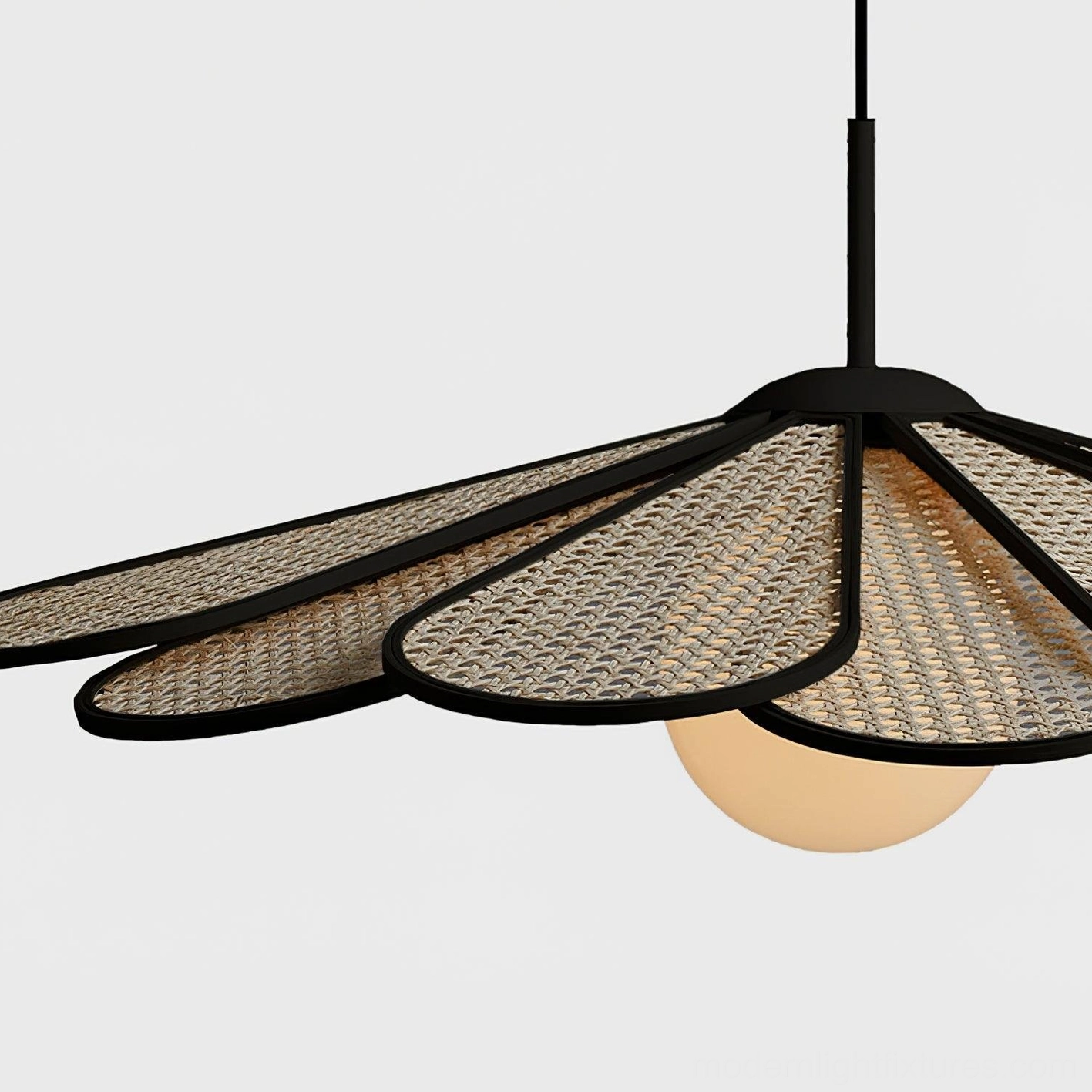 Black-trimmed rattan pendant light shown in clean minimalist space with natural light ambiance