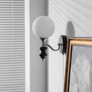 Black and white layered frosted glass globe wall sconce, side perspective in interior setting