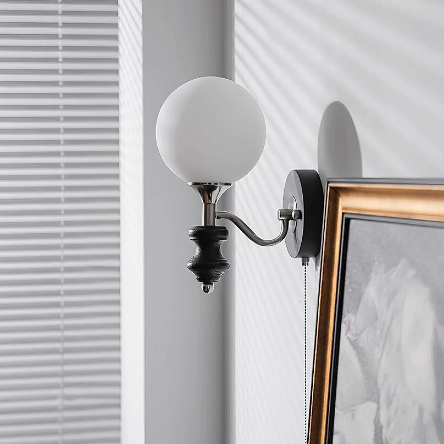 Black and white layered frosted glass globe wall sconce, side perspective in interior setting
