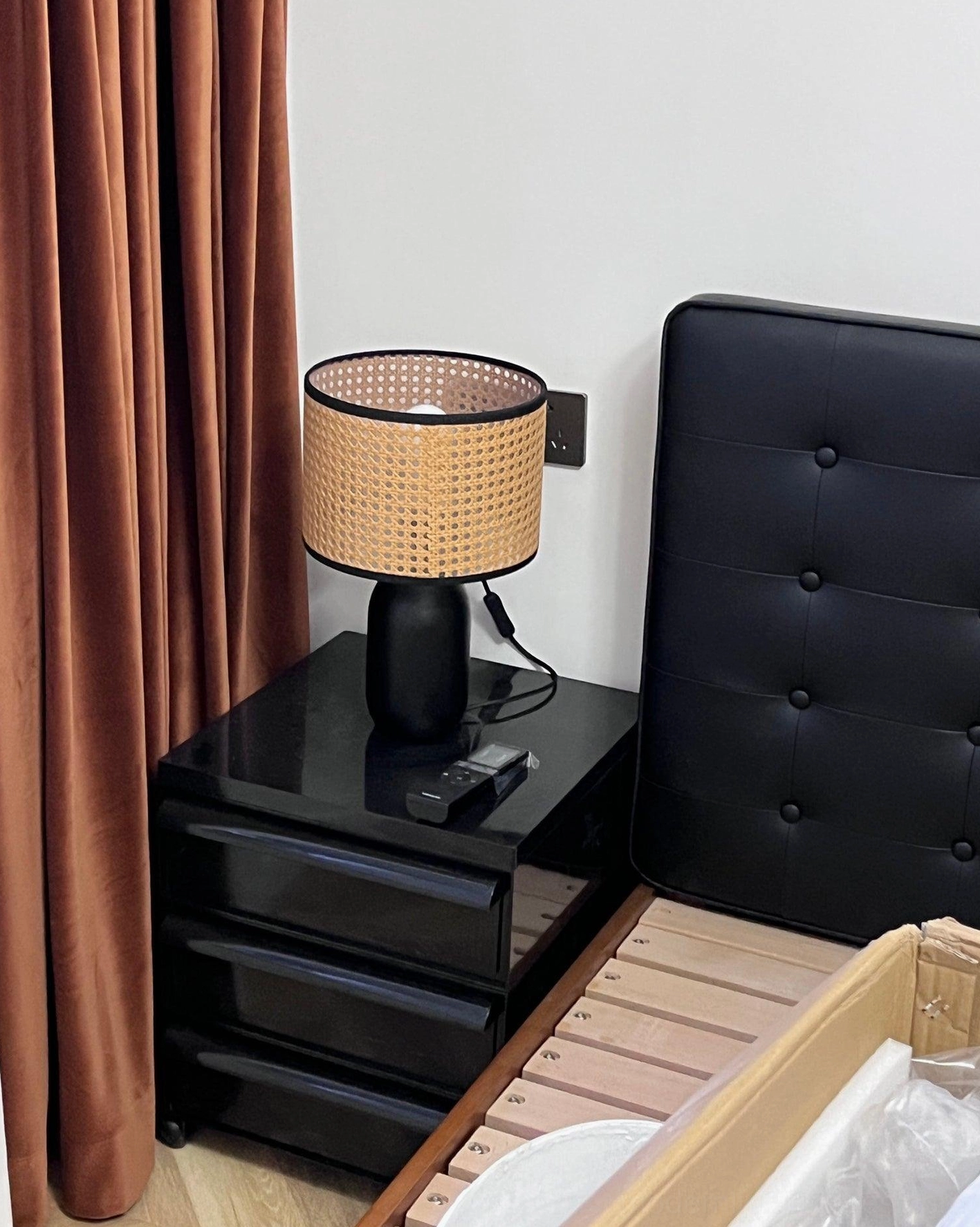 Blakely rattan table lamp styled with layered textiles and potted greenery