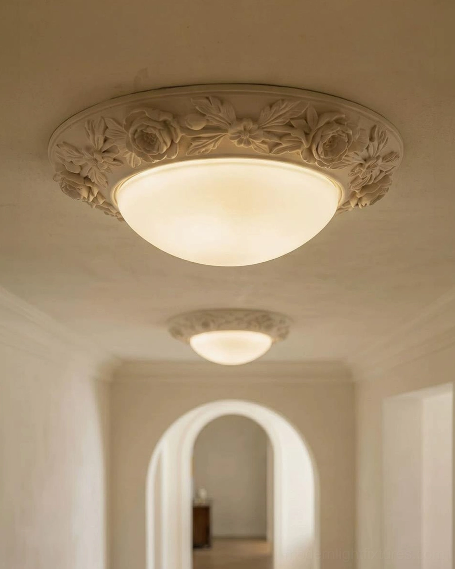 Blancora ceiling light close-up showing warm white LED glow through frosted glass dome with hand-carved gypsum-resin rim