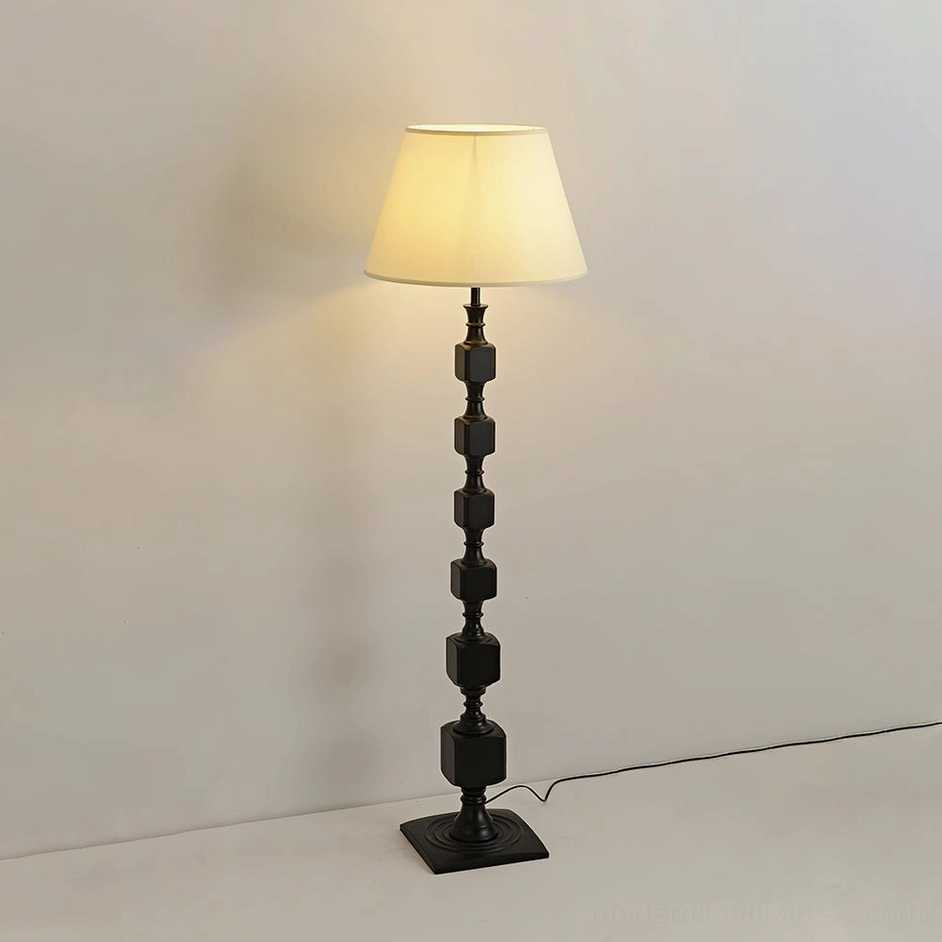 Matte black Blockora geometric floor lamp with square wooden base against minimalist plain wall, highlighting contemporary architectural form