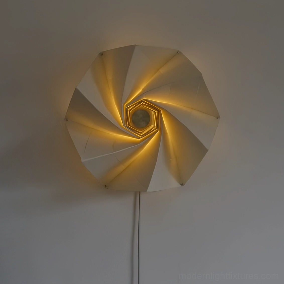 Bloom sculptural wall lamp with expanded shade emitting warm golden ambient glow, slightly angled front view
