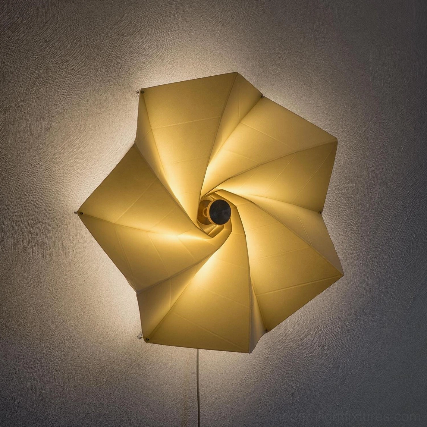 Close-up low angle view of Bloom illuminated wall sconce with exposed central fixture and folded shade
