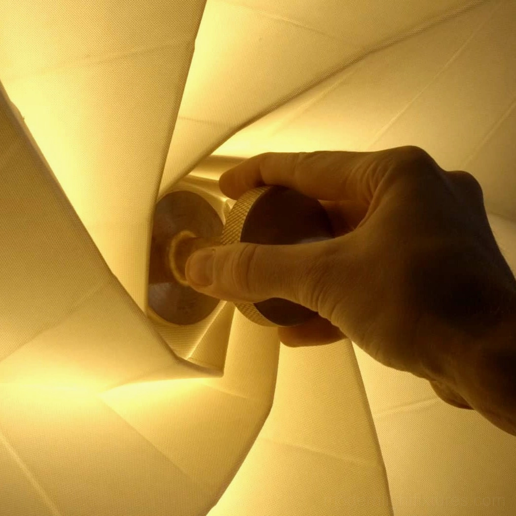 Bloom wall sconce closed position with compact sculptural profile, neutral beige color palette