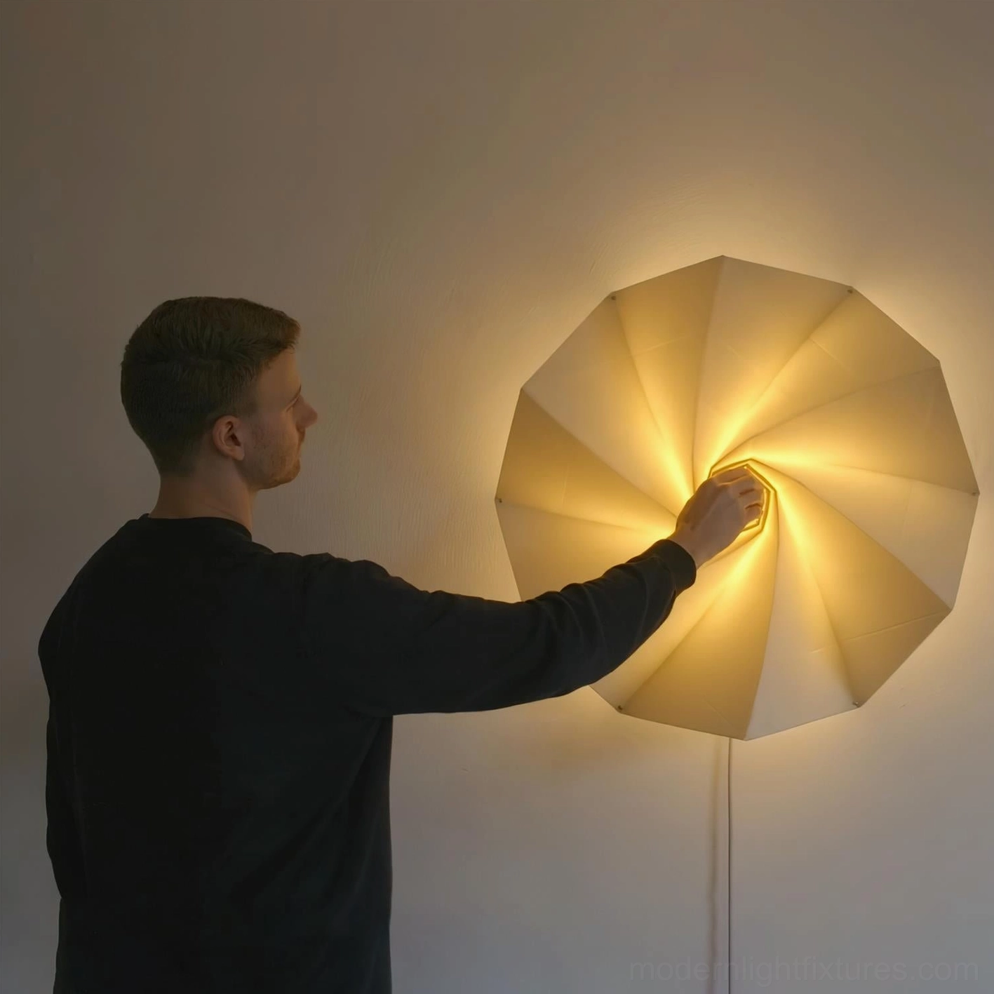 Man adjusting Bloom wall sconce dial mechanism to expand fabric shade, interactive modern lighting design