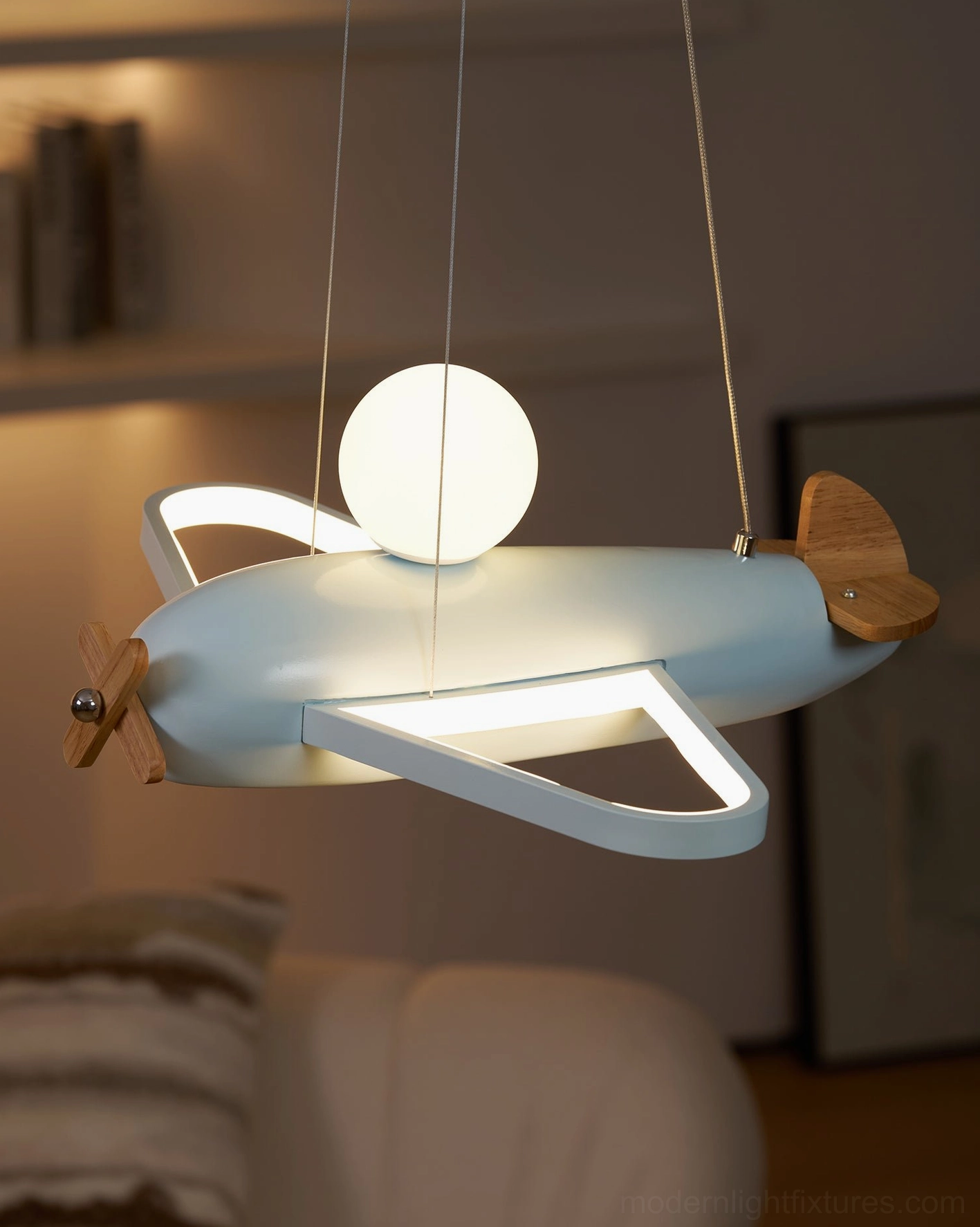 Blue airplane ceiling pendant showing color saturation and warm LED light output in dark room environment