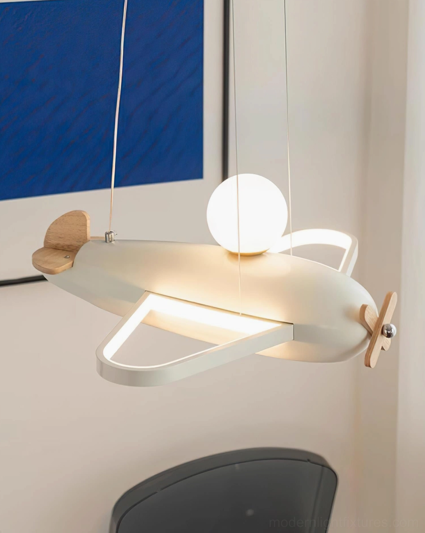 Blue airplane pendant lamp with wooden propeller showing sculptural design quality and modern aesthetics overhead