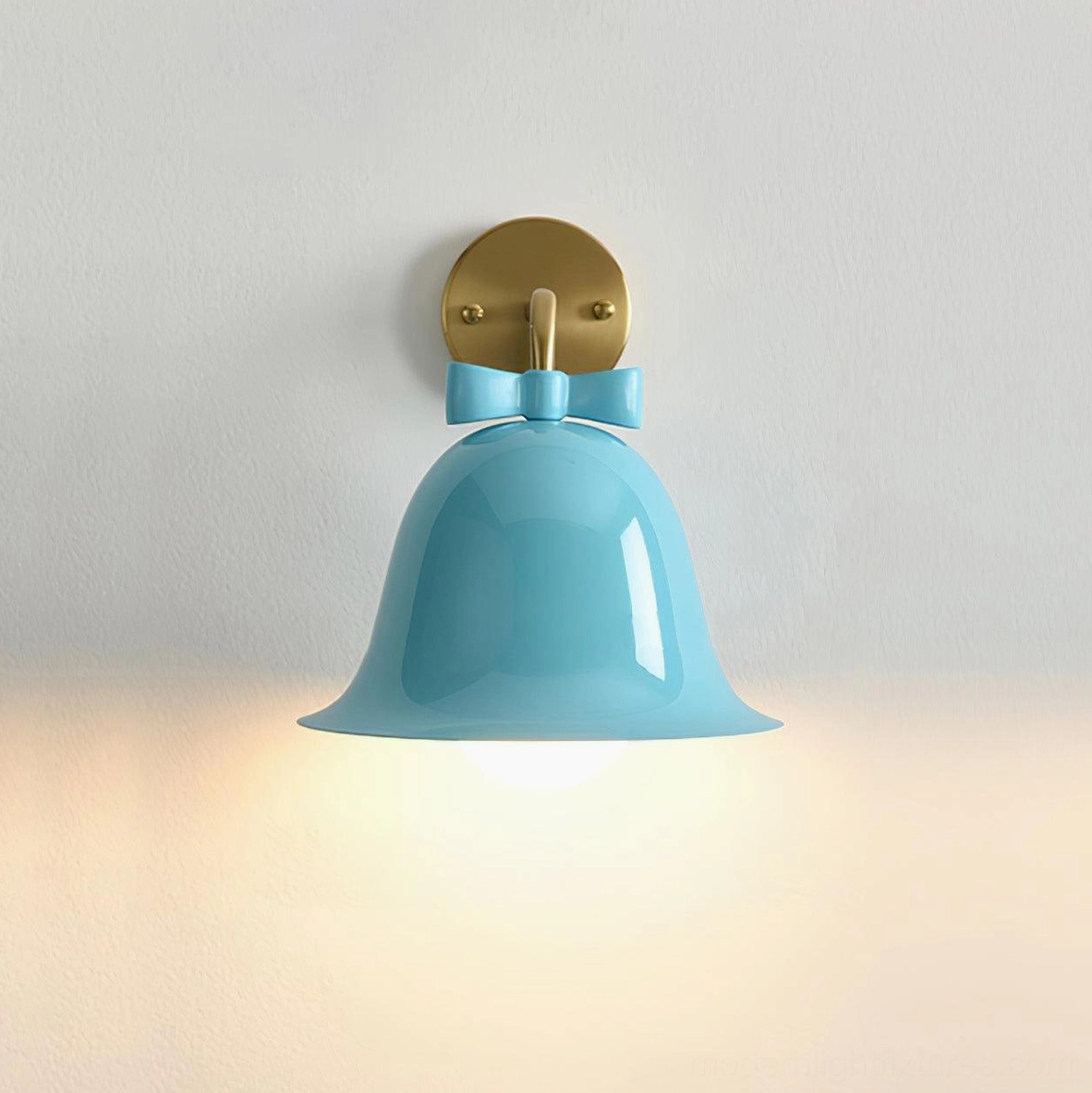 Blue bell-shaped ceramic wall lamp with decorative bow accent and warm brass hardware components