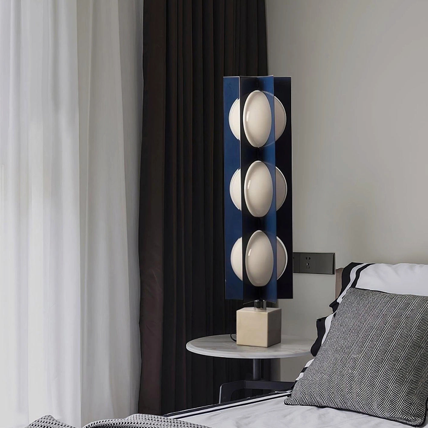 Compact blue glass floor lamp with 3 lit spheres positioned beside modern bedroom nightstand