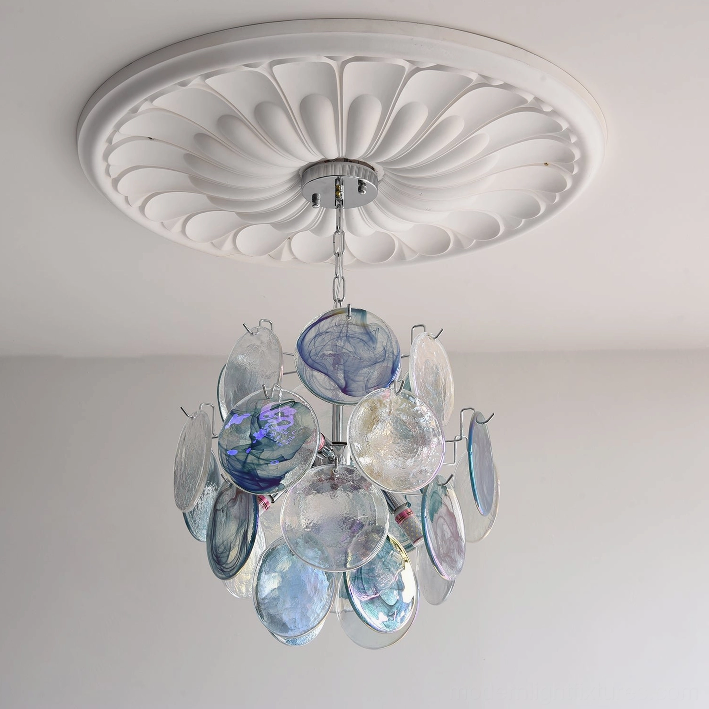 Blue color variant glass disc modern chandelier illuminated showing warm light distribution