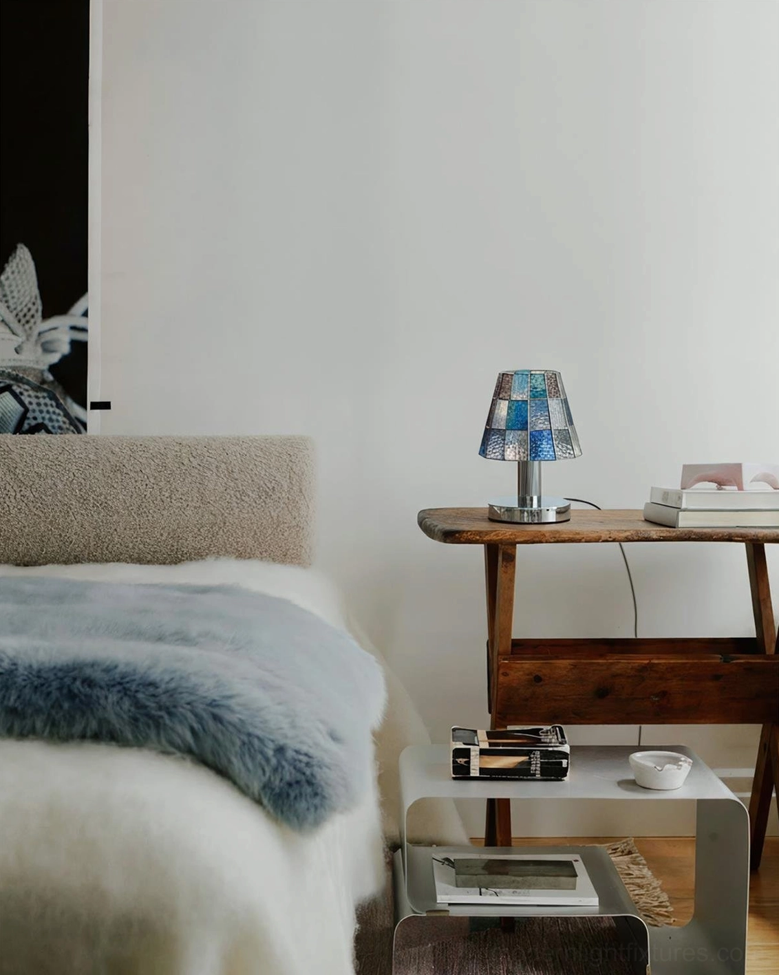 Blue stained glass geometric table lamp on bedroom nightstand creating cozy minimalist bedroom ambiance
