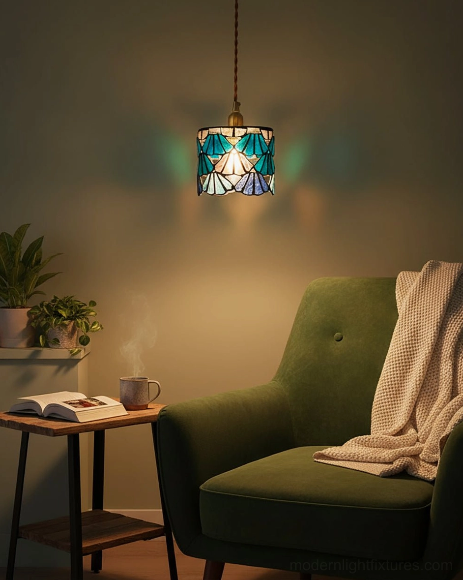 Blue Tiffany-style pendant light above reading area with dark green velvet armchair and home plants