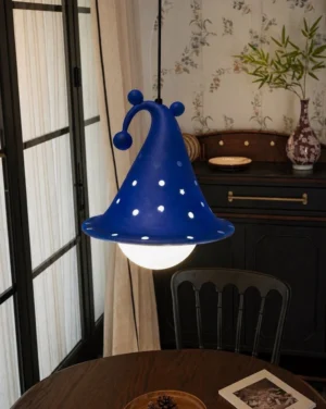 Blue wizard hat pendant light hanging in vintage dining room setting with wooden furniture and warm ambient lighting