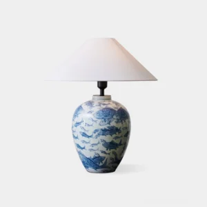 Blue and white ceramic table lamp with hand-painted fish motifs, direct front view showing globular porcelain base and white fabric shade