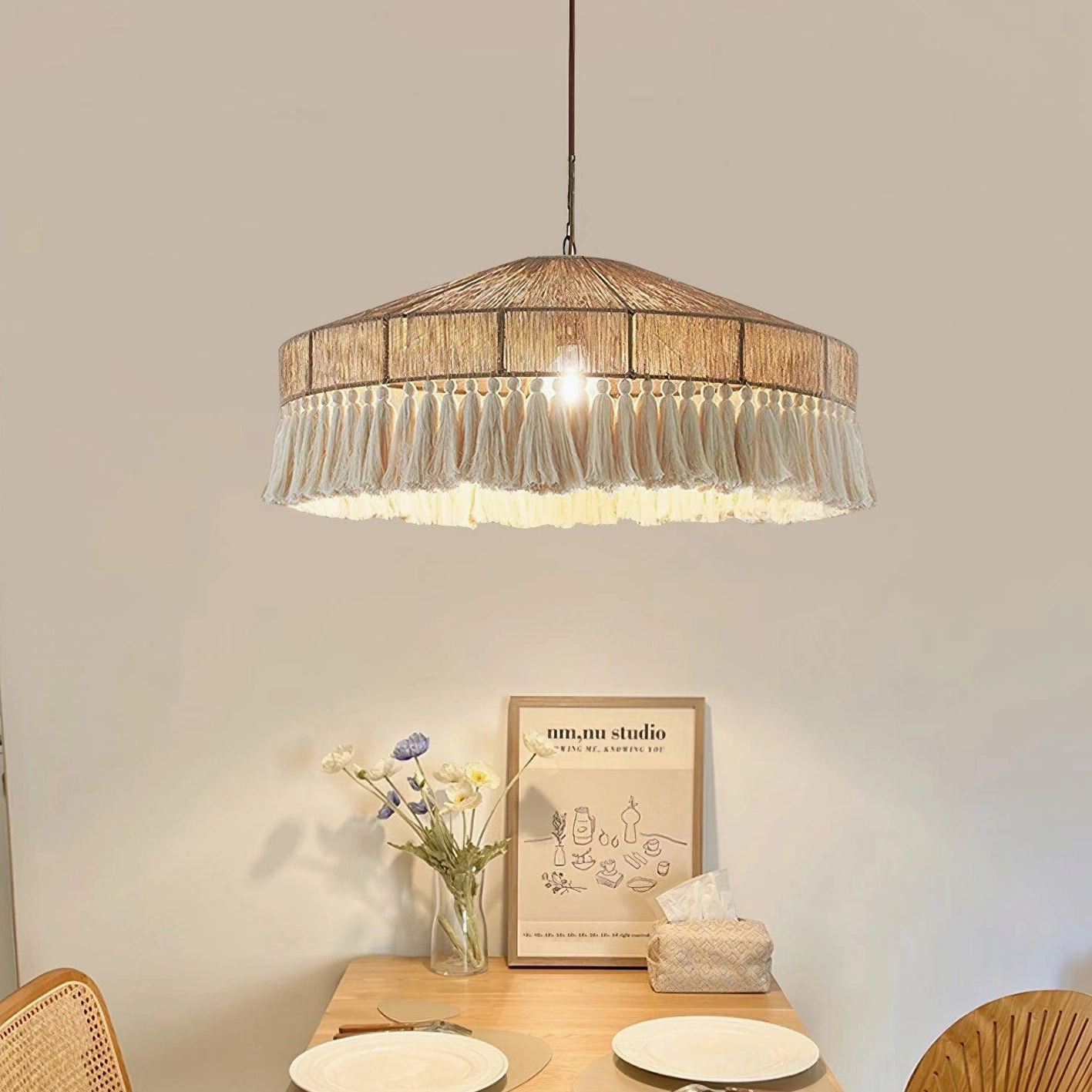 Handwoven bohemian fringe pendant lamp hanging in dining room with tableware and wall art, creating warm minimalist bohemian home decor ambiance