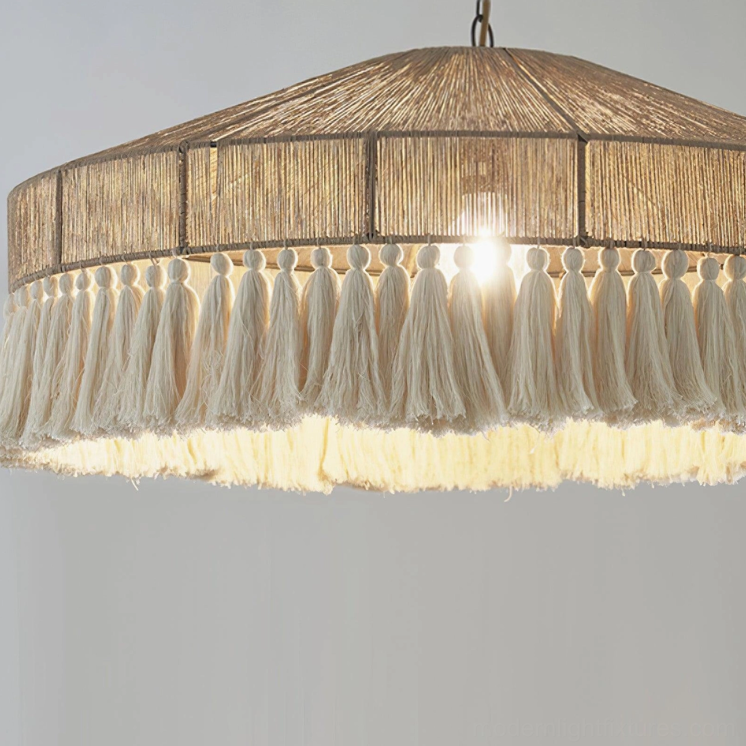 Bohemian tassel pendant light fixture viewed from below showing conical shape, cascading fringe elements and natural light diffusion through woven shade