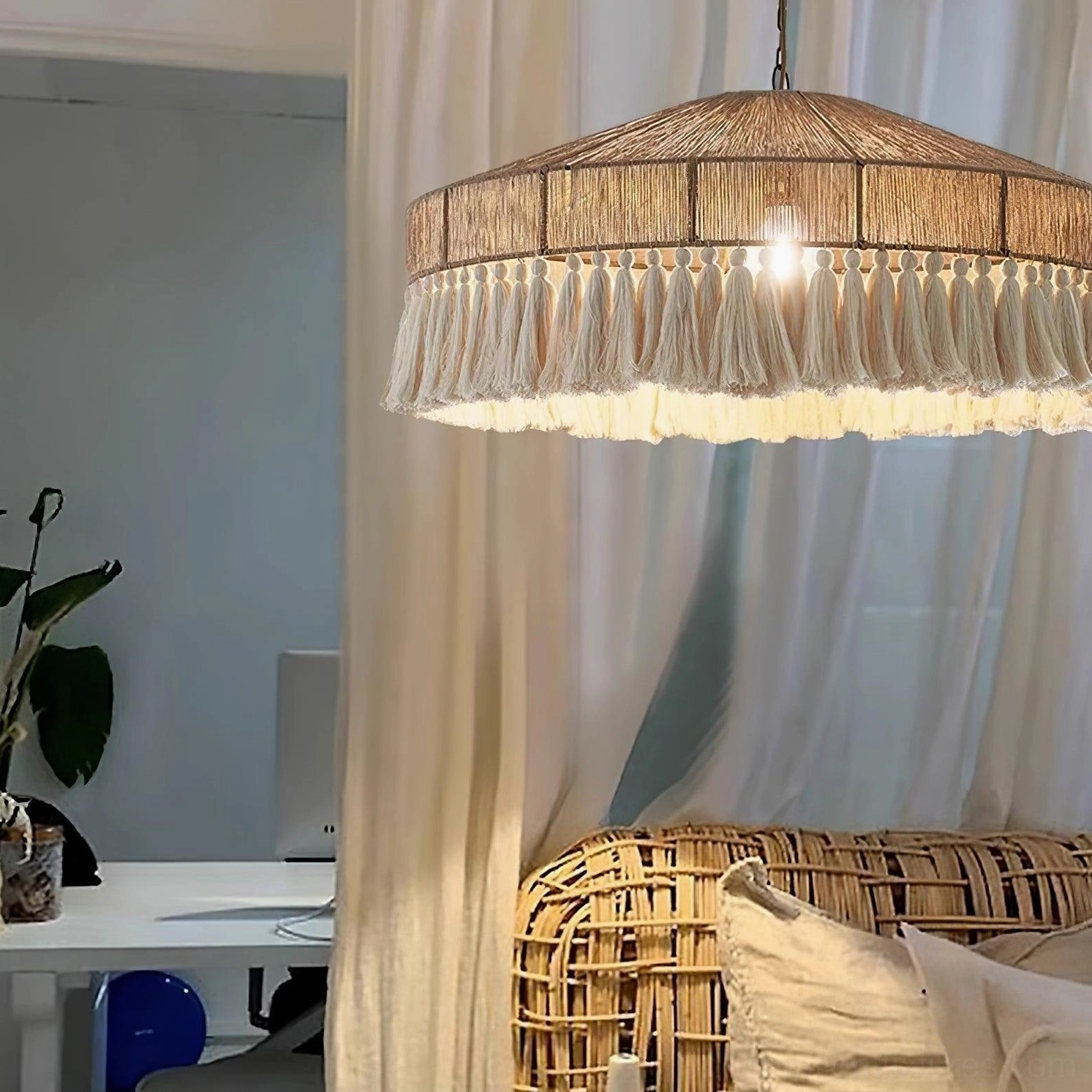 Bohemian tassel pendant light glowing above wicker sofa in home study and office space, warm bulb illumination highlighting natural tassel trim and artisanal craftsmanship