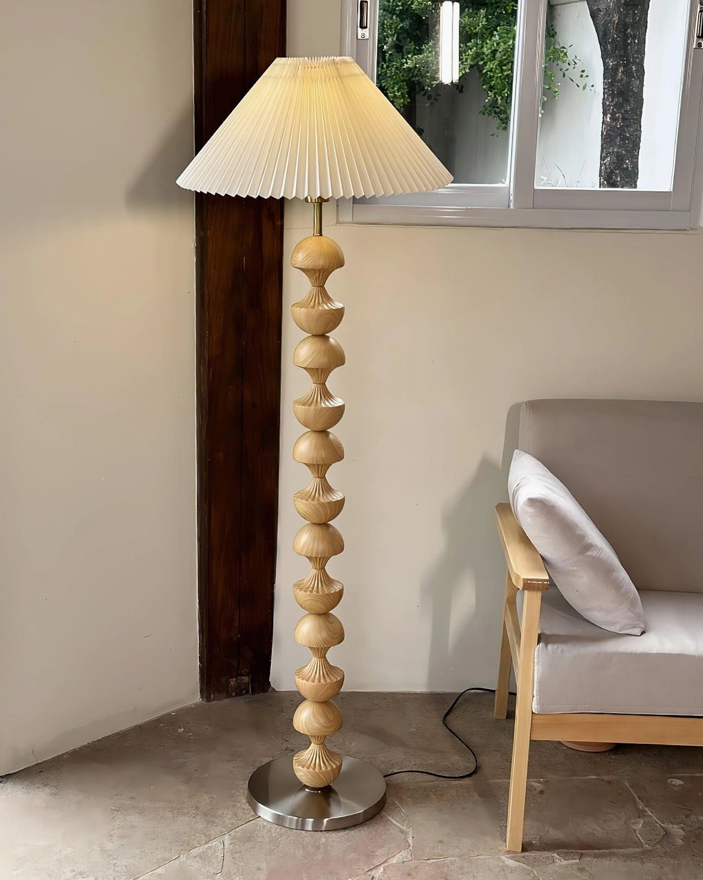 Light wood pole beaded floor lamp side view in living room with window and fabric armchair, silver round base, minimalist bohemian interior design