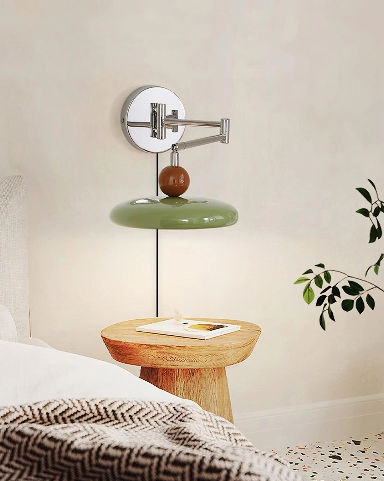 Olive green modern swing arm wall sconce with chrome hardware and hanging black power cord, bedroom bedside lighting setup