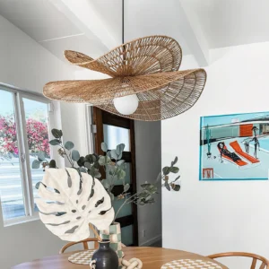 Bohemian rattan pendant lamp hanging over rustic dining table in residential interior, boho style dining room with warm lighting