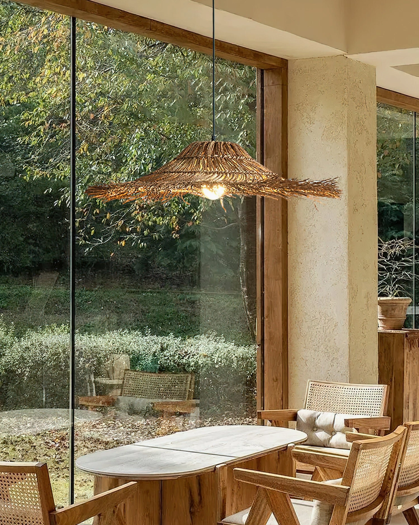 Rattan pendant light installed on covered patio in sunlit garden dining area, creating warm boho outdoor ambiance with natural light