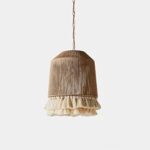 Handwoven boho tassel pendant light with off-white cotton gauze shade and flowing tassel fringe, studio top-down view