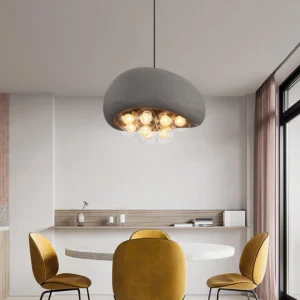Modern textured grey pendant light hung above round dining table with yellow chairs minimalist interior