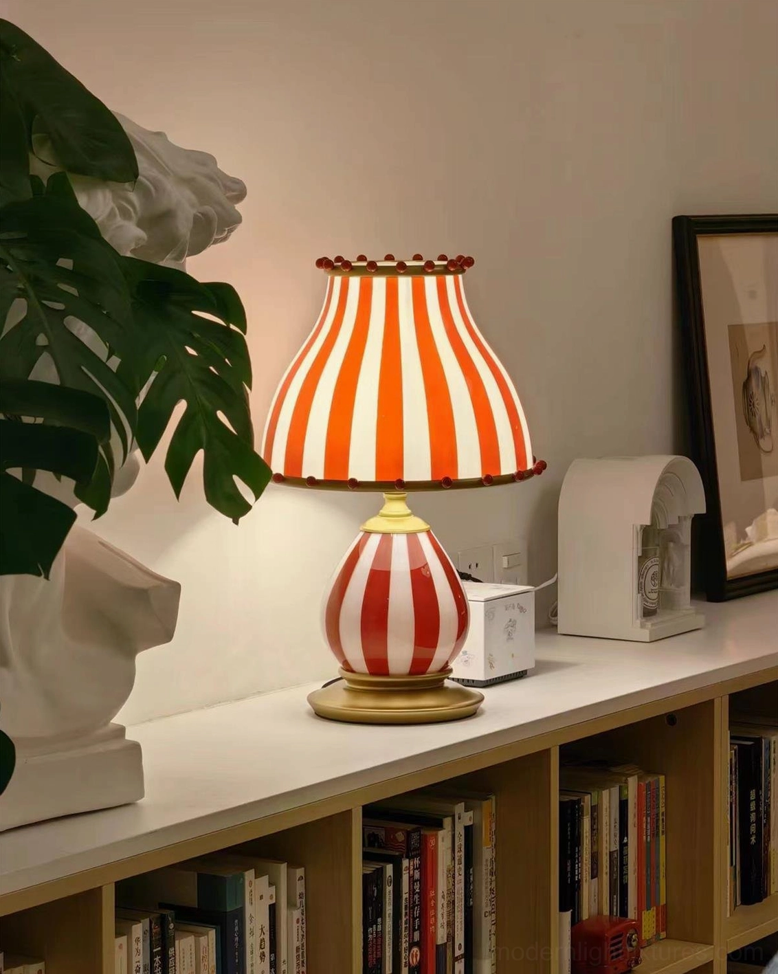 Bold red and white striped table lamp with elegant gold metal base