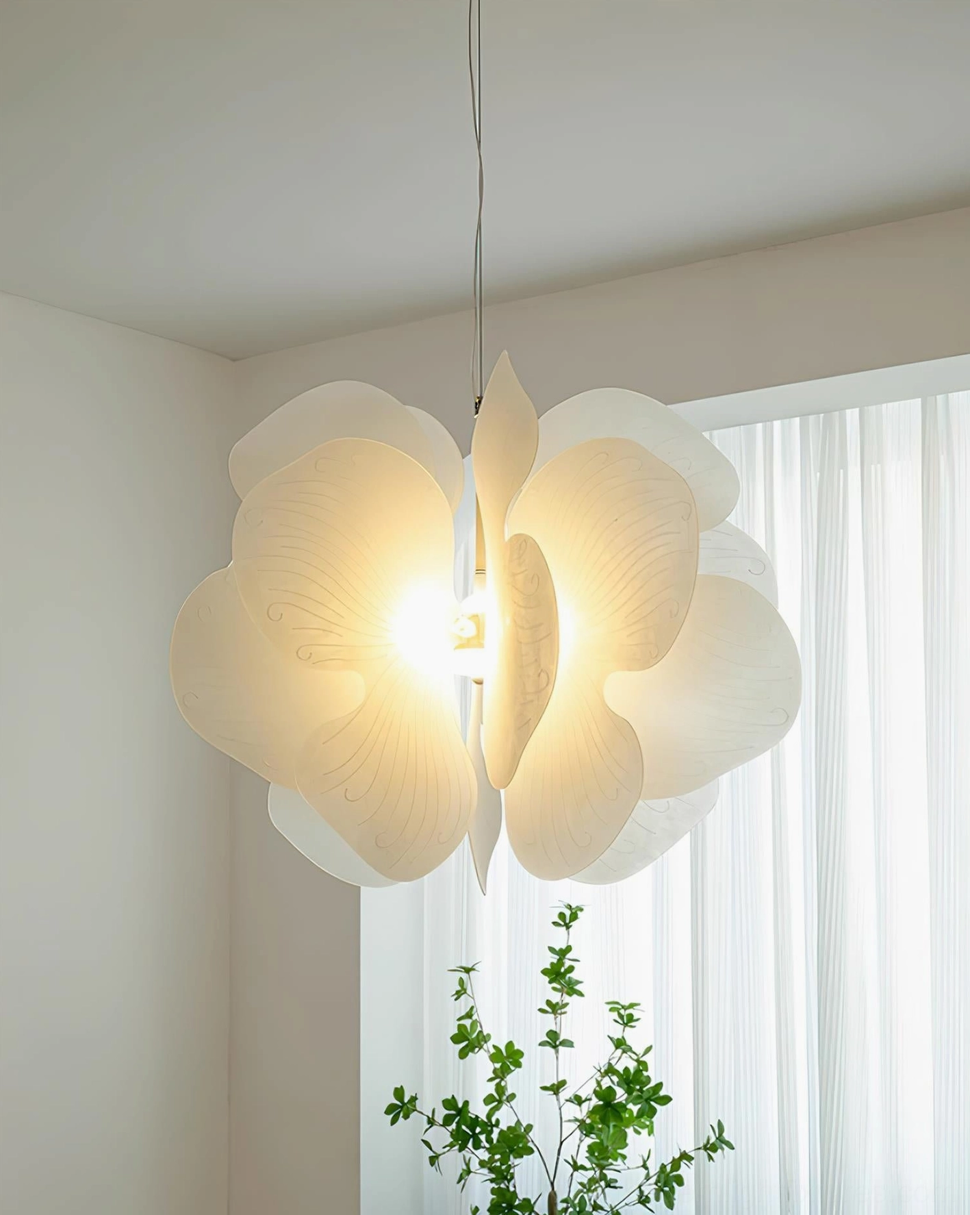 Bolide glowing pendant light in corner room - warm white illumination through organic petal form