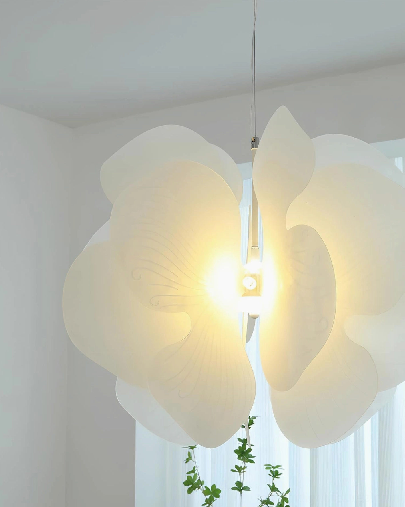 Bolide pendant light close-up illuminated - translucent acrylic petals with warm central glow detail