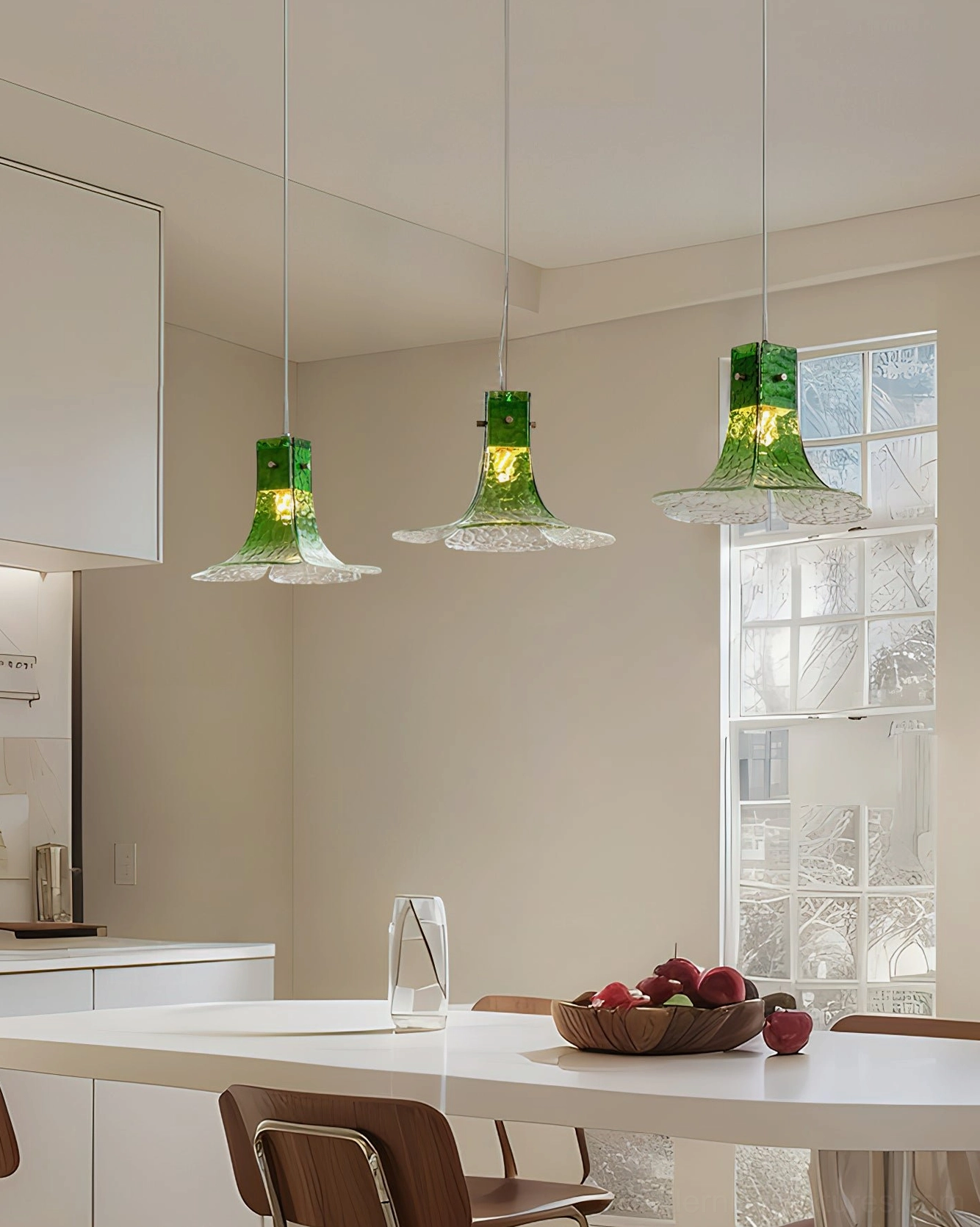 Cluster of three hand-blown glass botanical pendant lights suspended over modern kitchen dining table