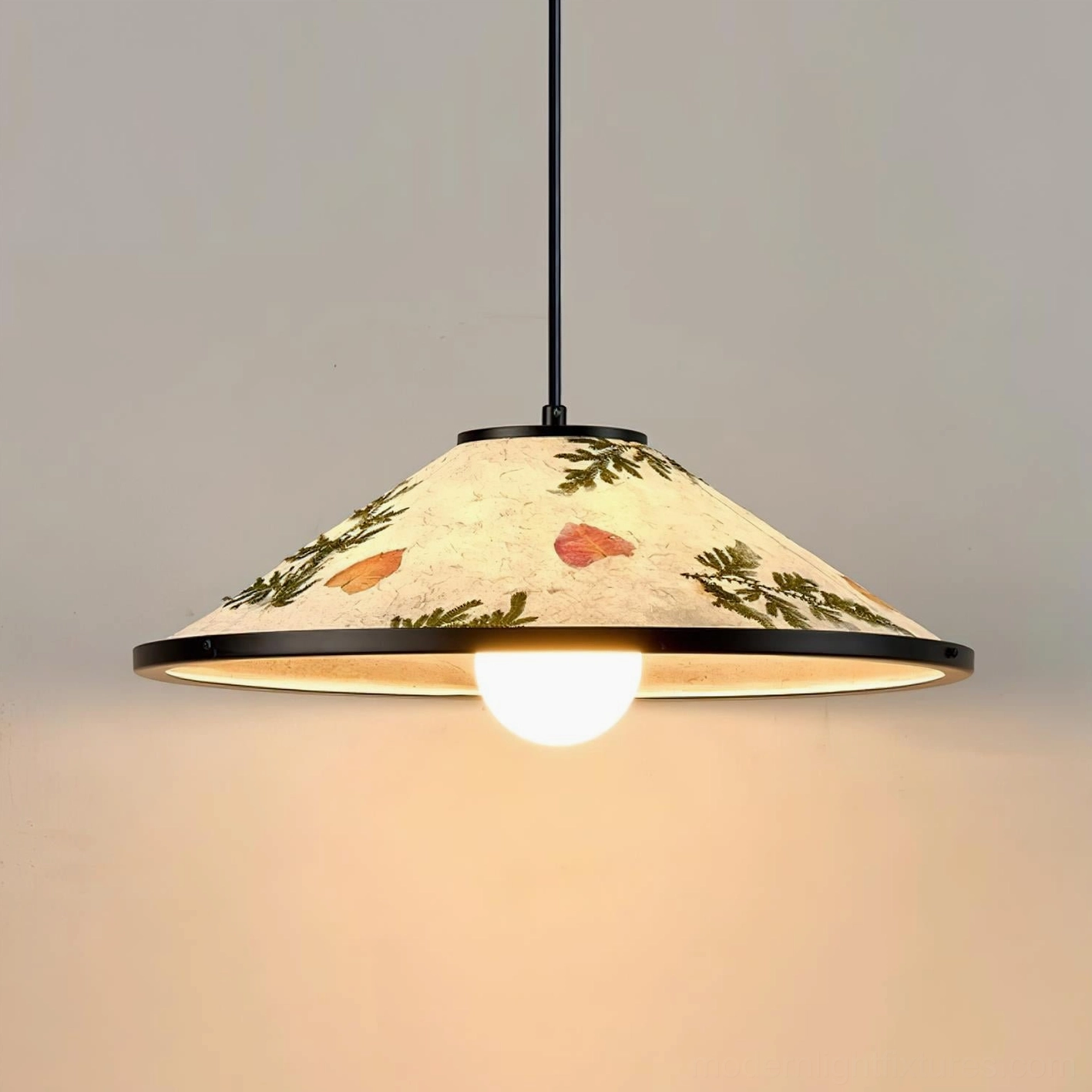 Botanical pendant light with exposed bulb glowing warm inside beige rice paper shade with embedded dried leaves
