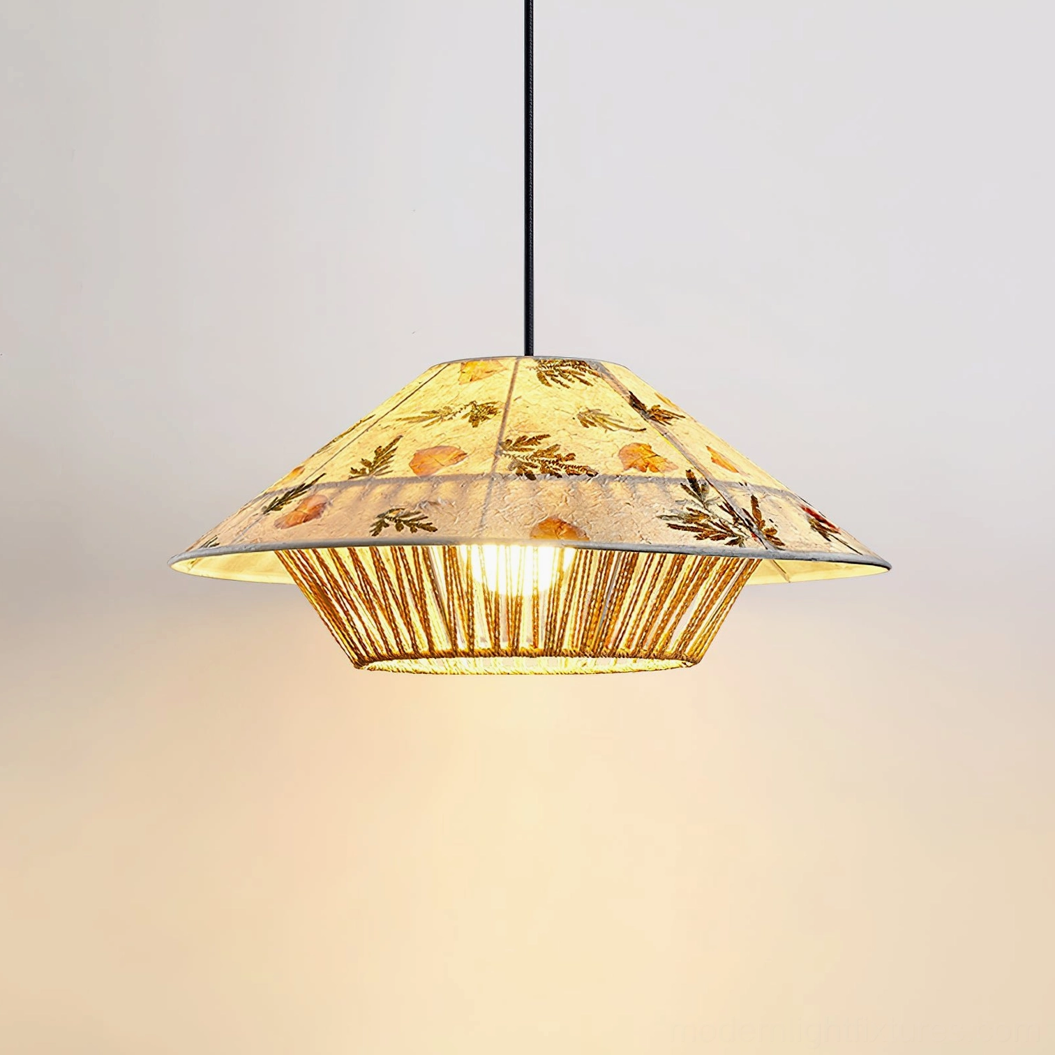Illuminated botanical pendant lamp three-quarter view highlighting pressed floral rice paper design and warm light diffusion