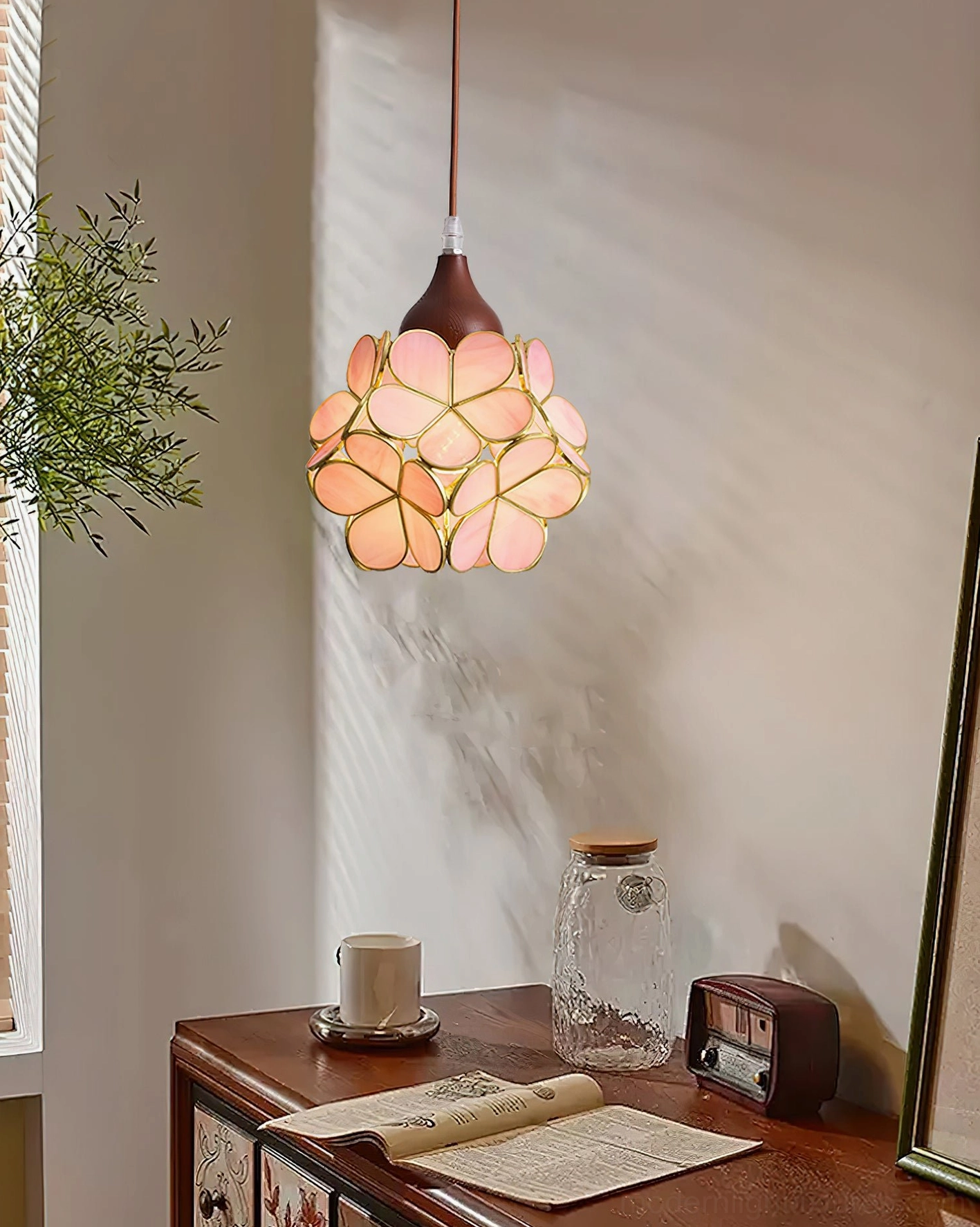 Flower pendant light installed over vintage wooden desk area with warm ambient lighting and green plant decor