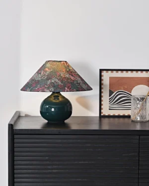 Modern botanical table lamp displayed on bedroom dresser with fluted black cabinet creating cozy ambient lighting in home interior