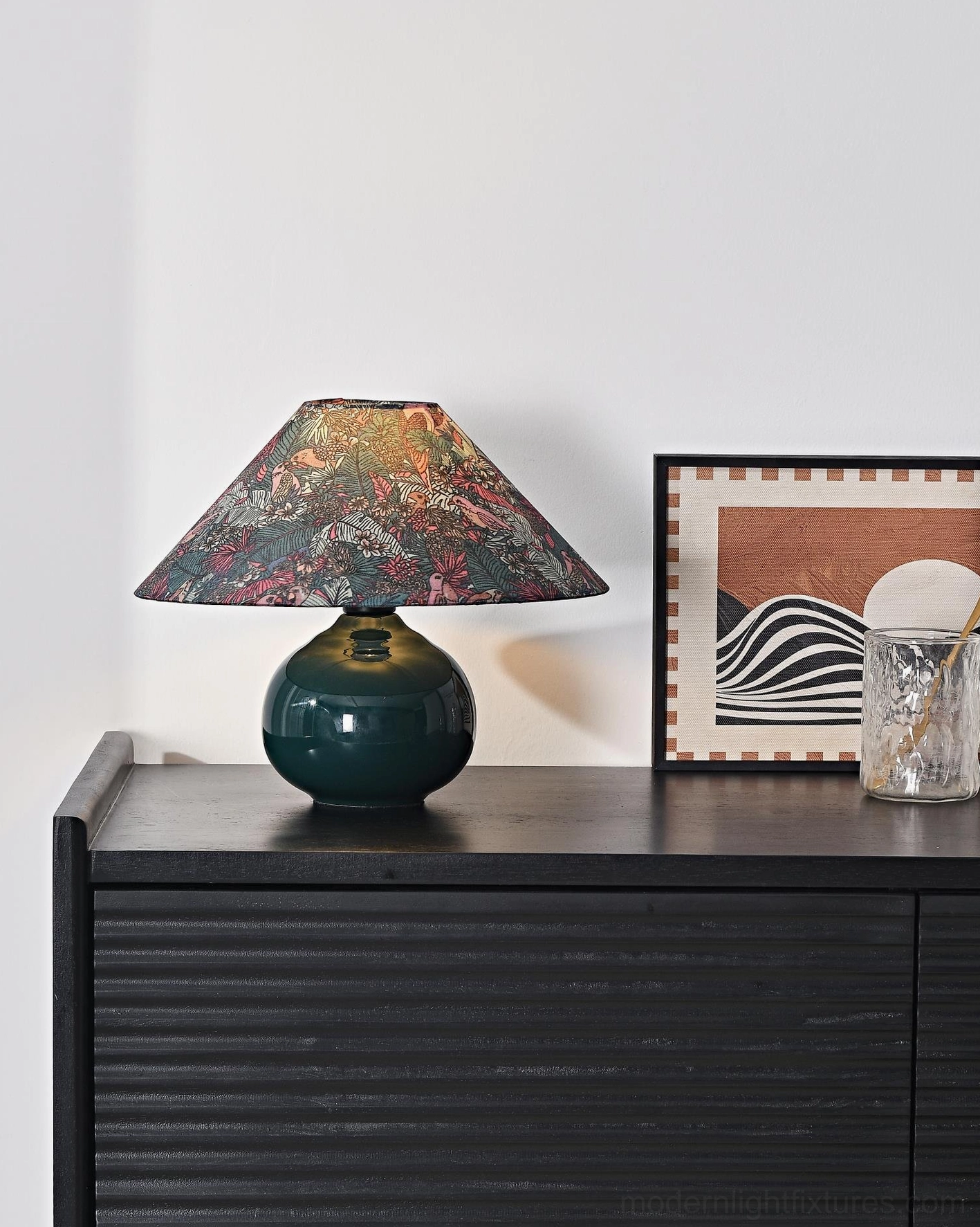 Modern botanical table lamp displayed on bedroom dresser with fluted black cabinet creating cozy ambient lighting in home interior