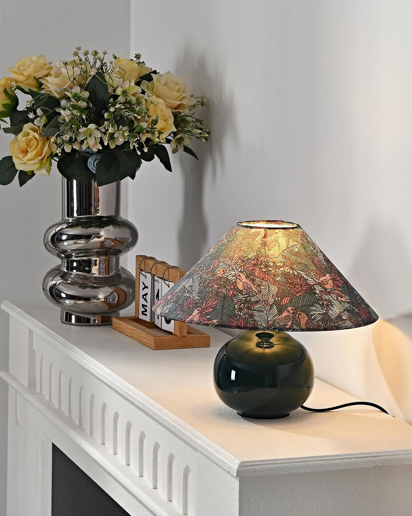 Botanical table lamp styled in minimalist contemporary bedroom creating nature-inspired sanctuary with warm localized lighting