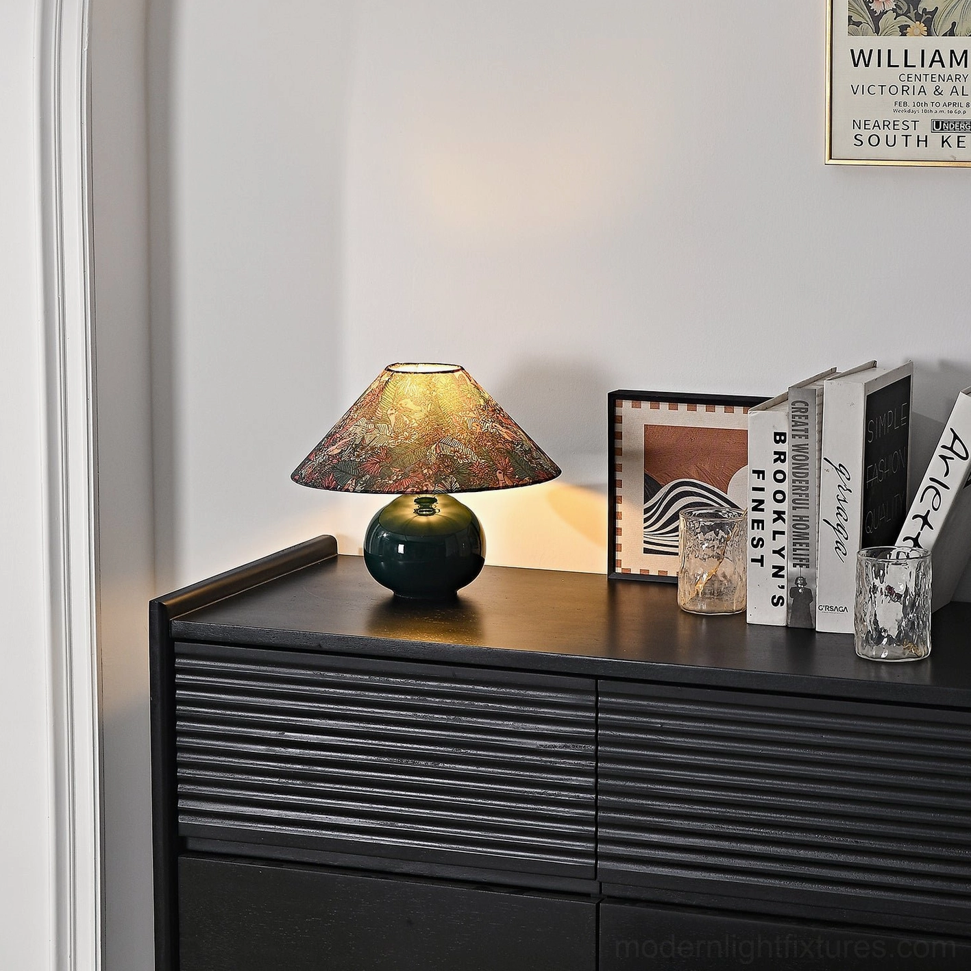 Contemporary botanical table lamp bedside setup showing forest green ceramic base with fabric shade and decorative home accessories